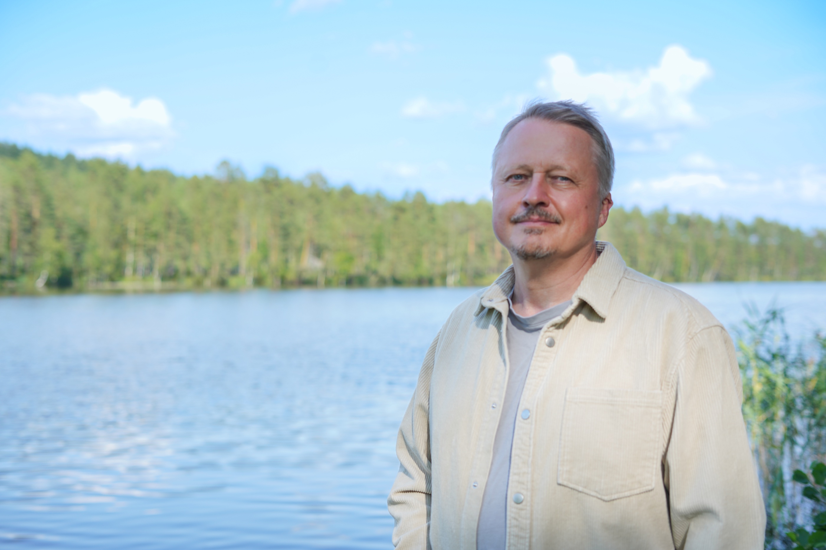 Nikolai Beliaev at Nordic lake, summer light, forest shoreline visible